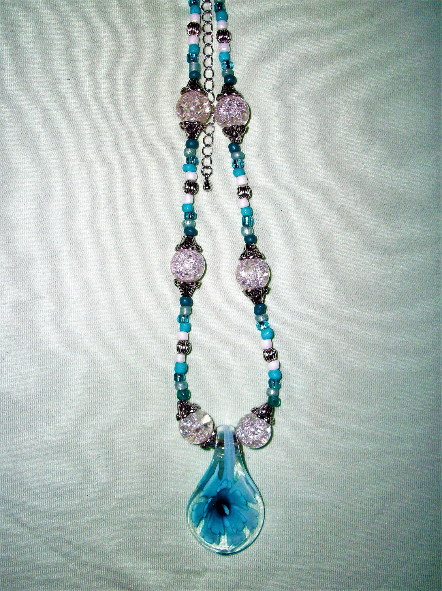 Blue necklace with a blue flower pendant.